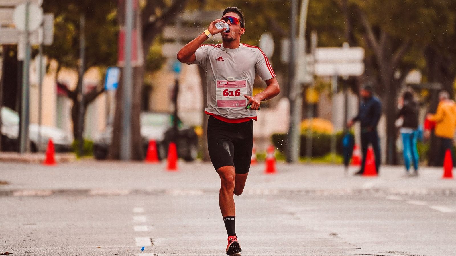 Coureur buvant à une bouteille pendant un marathon pour tester son ravitaillement