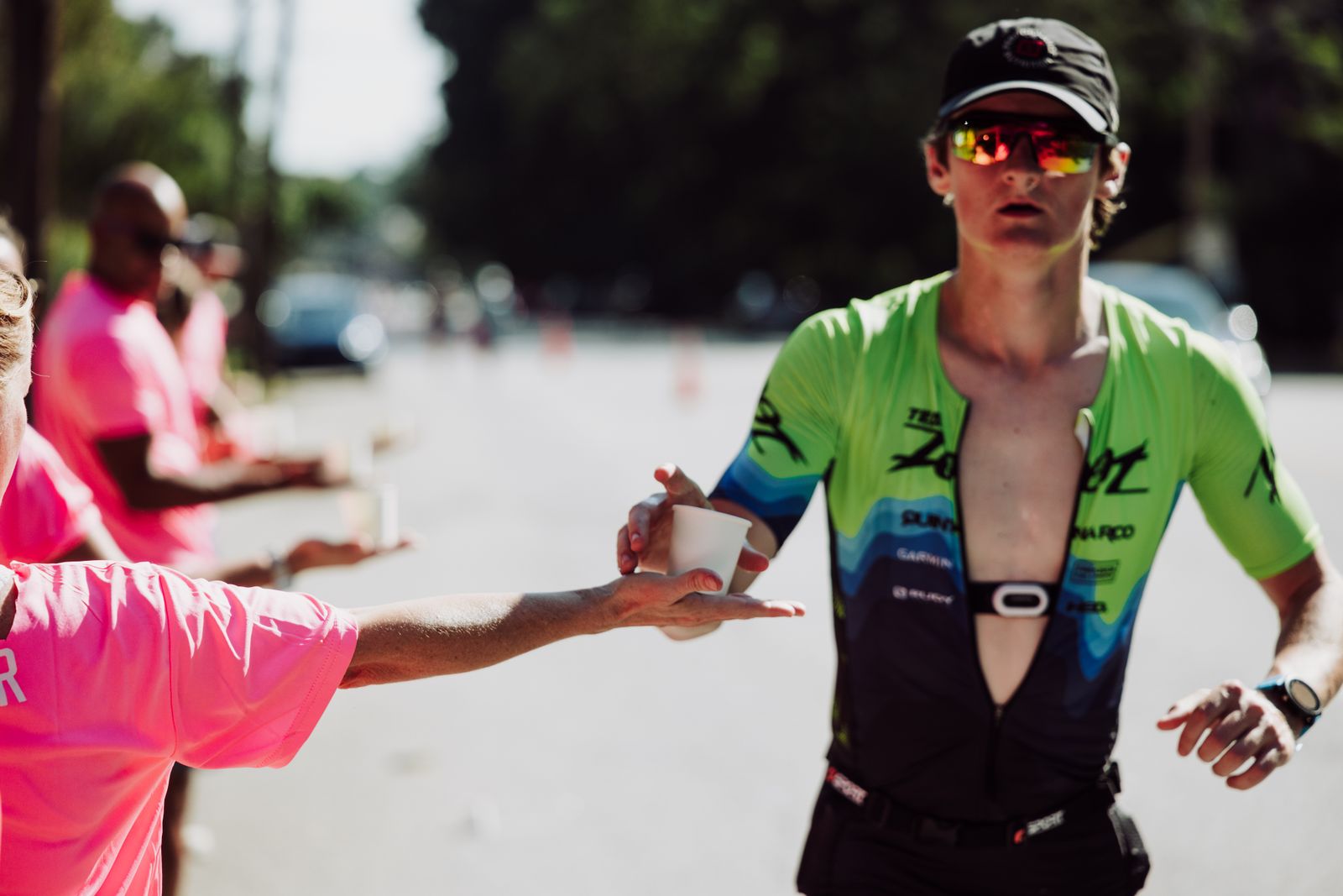 Marathonien recevant un verre d'eau à une zone de ravitaillement
