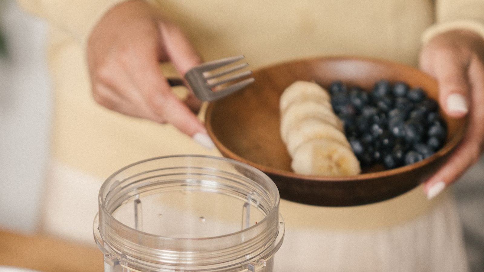 Préparation d'un smoothie aux fruits avec banane et fruits rouges