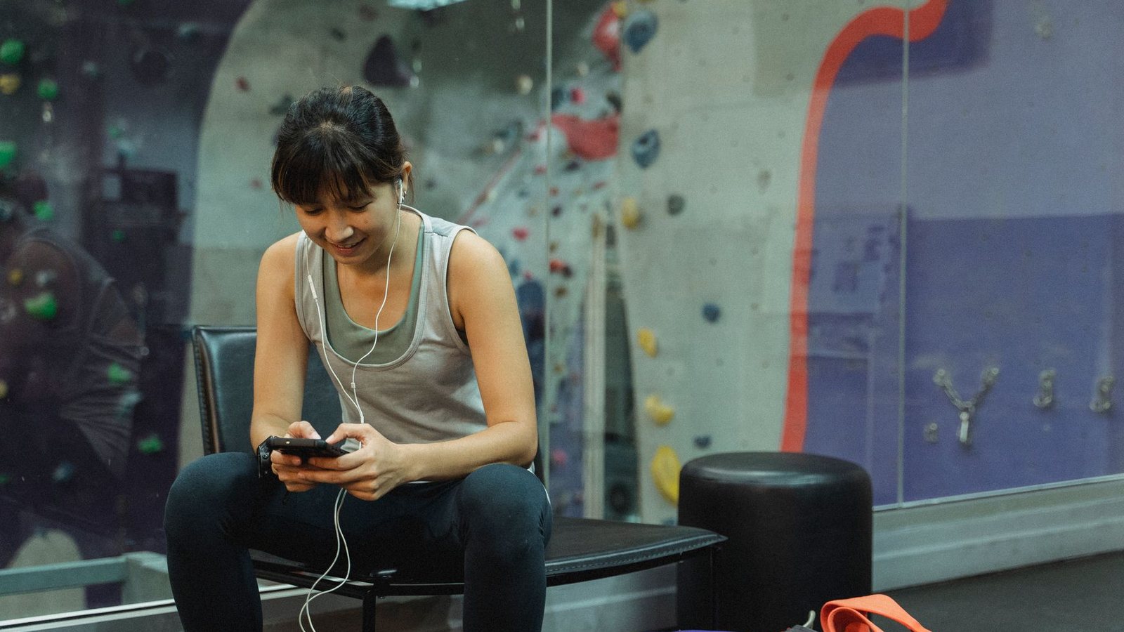 Sportive consultant son téléphone pour organiser un programme complémentaire après son entraînement
